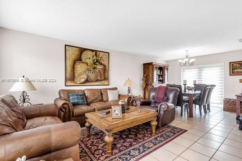 tiled living room featuring an inviting chandelier