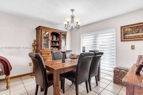 dining space featuring a textured ceiling, a chandelier, and light tile floors