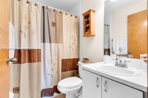 bathroom with large vanity and toilet