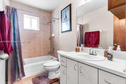 full bathroom featuring shower / tub combo with curtain, vanity, and toilet