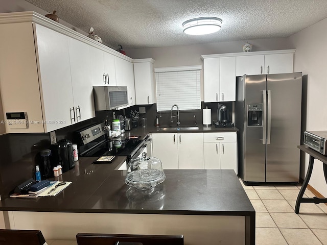 kitchen with sink, white cabinets, light tile floors, and appliances with stainless steel finishes