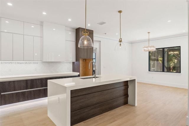 kitchen with decorative backsplash, dark brown cabinetry, sink, decorative light fixtures, and white cabinetry