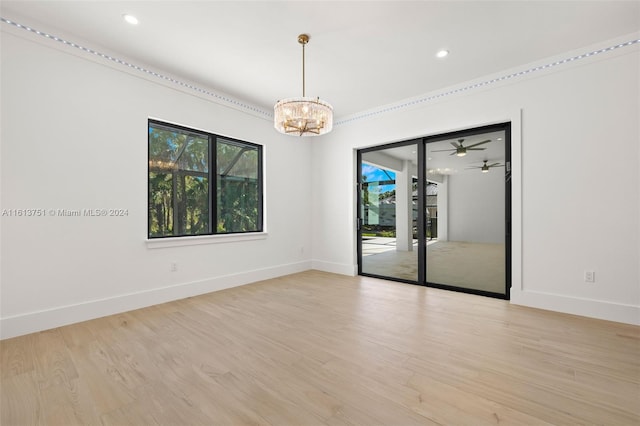 spare room with light hardwood / wood-style flooring and ceiling fan with notable chandelier