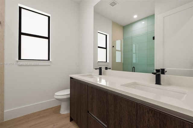 bathroom with vanity, toilet, a shower with door, and wood-type flooring