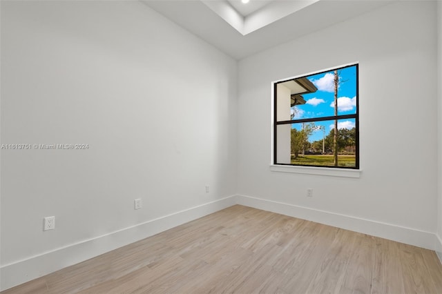 spare room featuring light hardwood / wood-style floors and lofted ceiling