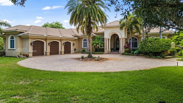 mediterranean / spanish-style house featuring a front yard and a garage