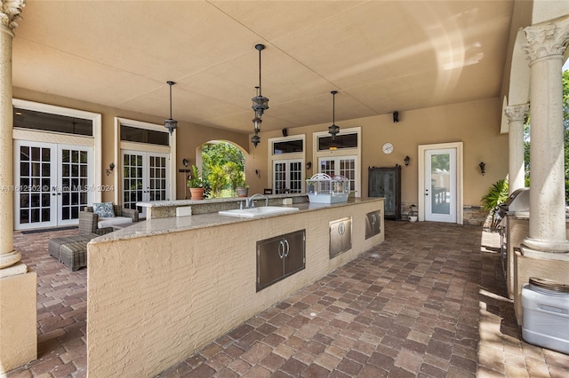 view of terrace featuring sink, french doors, ceiling fan, and an outdoor kitchen