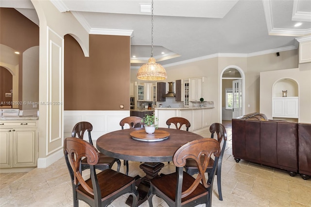 dining area with ornamental molding, a tray ceiling, and light tile flooring