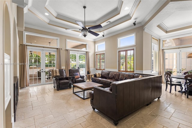 living room featuring ceiling fan, a tray ceiling, french doors, and crown molding