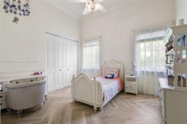 bedroom featuring ceiling fan, a closet, light parquet flooring, and ornamental molding