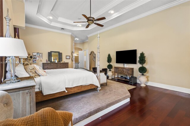 bedroom featuring ceiling fan, ornamental molding, a tray ceiling, and dark hardwood / wood-style floors