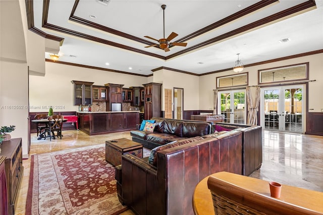 living room featuring ceiling fan, a tray ceiling, ornamental molding, french doors, and light tile floors