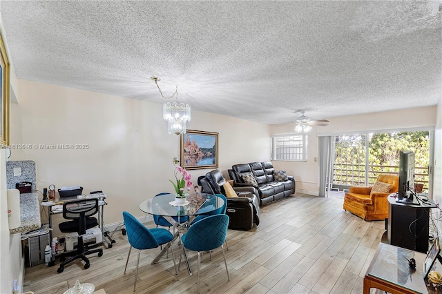 11091 NW 7th St Unit 202, Miami, FL 33172 - dining area featuring a textured ceiling, ceiling fan with notable chandelier, and light wood finished floors