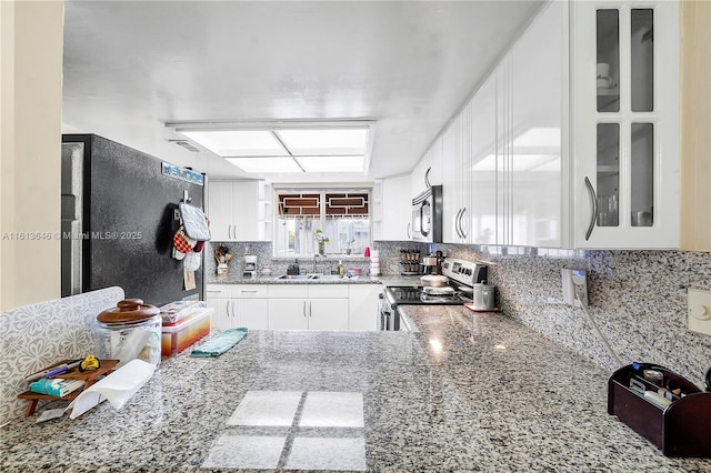 11091 NW 7th St Unit 202, Miami, FL 33172 - kitchen featuring glass insert cabinets, tasteful backsplash, white cabinetry, light stone counters, and stainless steel appliances