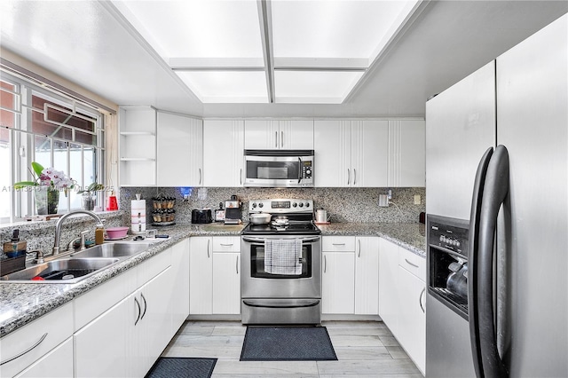 11091 NW 7th St Unit 202, Miami, FL 33172 - kitchen with open shelves, white cabinetry, a sink, stainless steel appliances, and backsplash