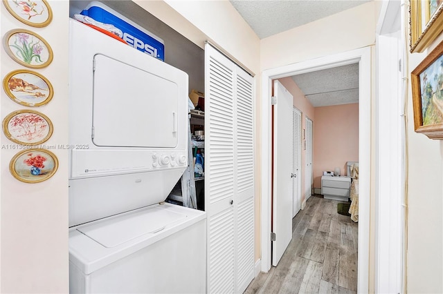 11091 NW 7th St Unit 202, Miami, FL 33172 - laundry area with light wood-style flooring, a textured ceiling, and stacked washer and dryer