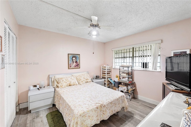 11091 NW 7th St Unit 202, Miami, FL 33172 - bedroom featuring a closet, baseboards, ceiling fan, a textured ceiling, and wood finished floors