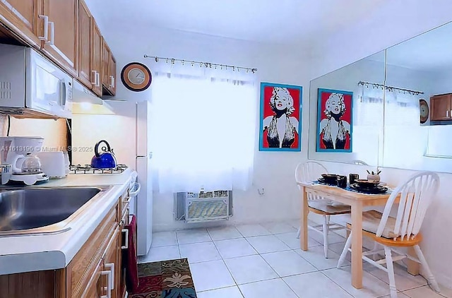 kitchen with light tile patterned floors, a wall mounted AC, and extractor fan