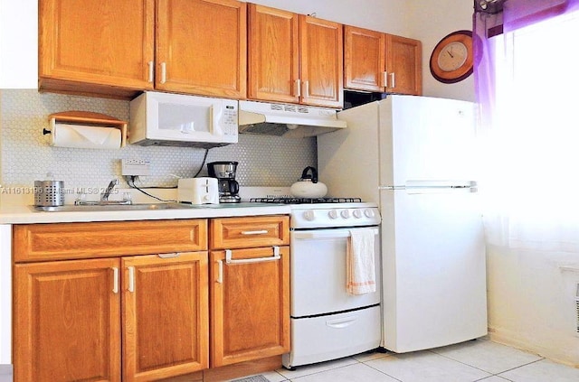 kitchen with light tile patterned floors, white appliances, sink, and decorative backsplash