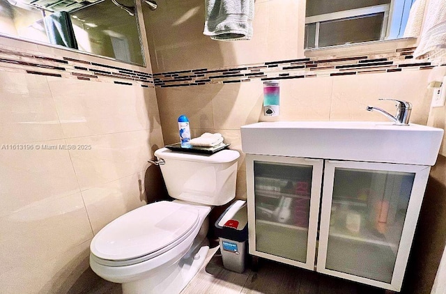 bathroom featuring vanity, backsplash, tile walls, and toilet