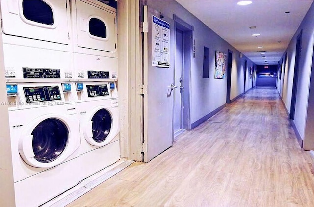 laundry area featuring stacked washer and dryer and light hardwood / wood-style floors