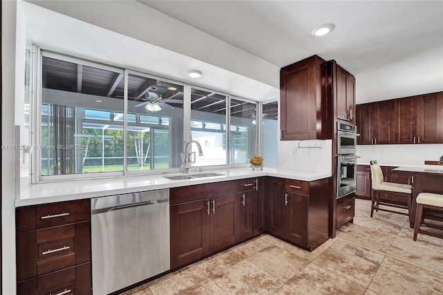 kitchen with light countertops, appliances with stainless steel finishes, a sink, and a healthy amount of sunlight