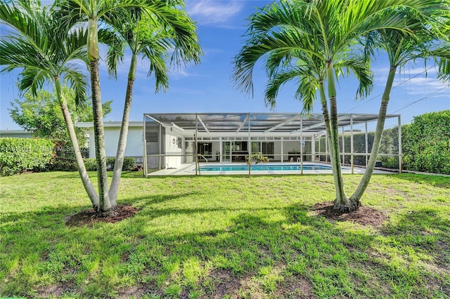 back of house with glass enclosure, an outdoor pool, and a yard