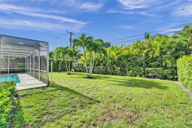 view of yard featuring glass enclosure and an outdoor pool