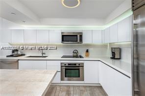 kitchen with white cabinetry, appliances with stainless steel finishes, sink, and light wood-type flooring