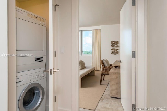 clothes washing area with stacked washer and dryer