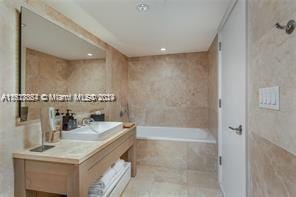 bathroom with vanity and tile walls