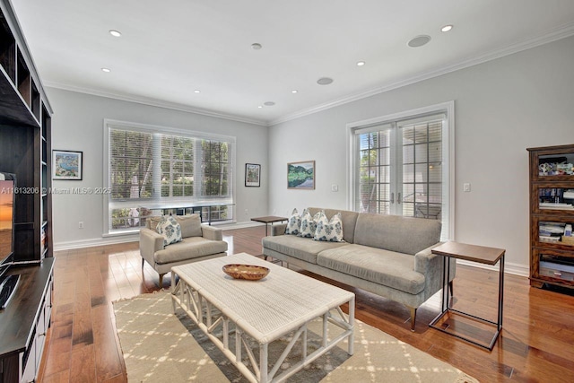 living room featuring crown molding, light hardwood / wood-style flooring, and french doors