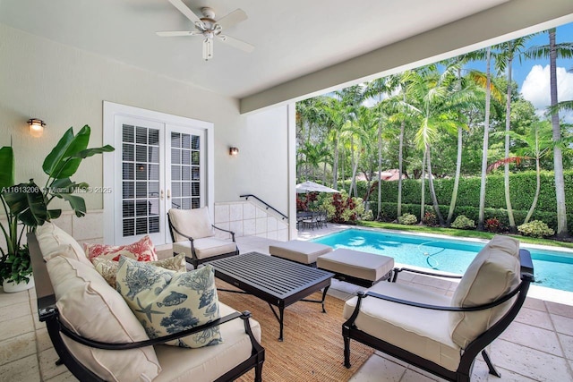 view of patio with a fenced in pool, an outdoor living space, ceiling fan, and french doors