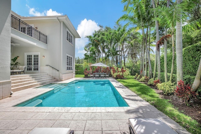 view of swimming pool featuring a patio area, french doors, and ceiling fan