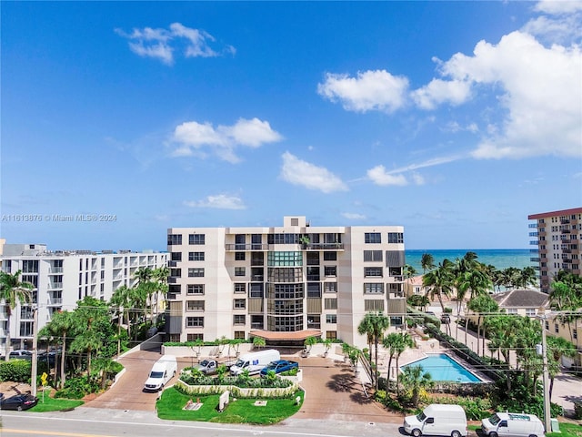 view of building exterior featuring a community pool and a water view