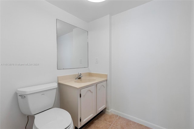 bathroom with tile flooring, oversized vanity, and toilet