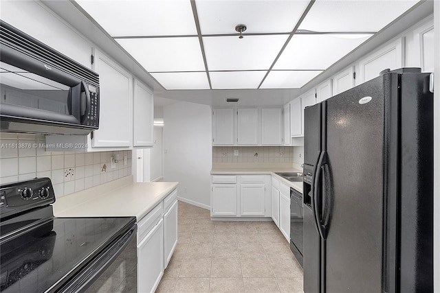 kitchen with light tile flooring, black appliances, backsplash, sink, and white cabinetry