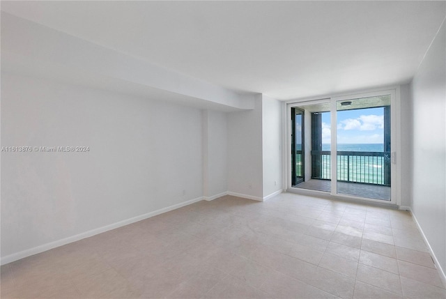 unfurnished room featuring light tile floors and expansive windows