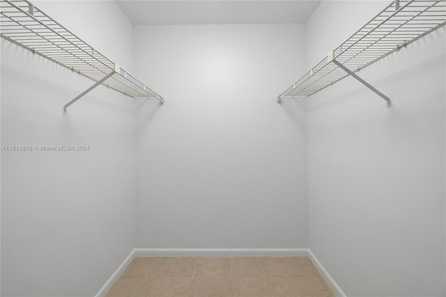 walk in closet with tile flooring