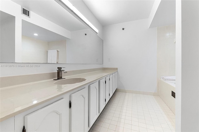 bathroom featuring tile floors, tiled bath, and vanity