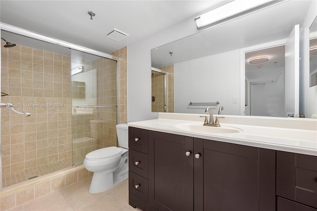 bathroom featuring walk in shower, tile flooring, vanity with extensive cabinet space, and toilet