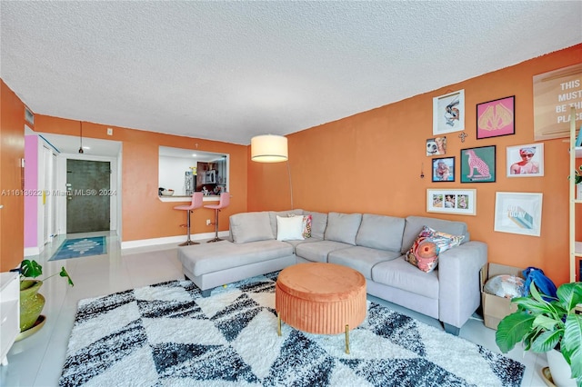 living room with tile patterned flooring and a textured ceiling