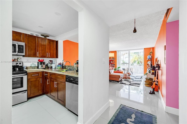 kitchen featuring a textured ceiling, light tile patterned flooring, sink, and stainless steel appliances