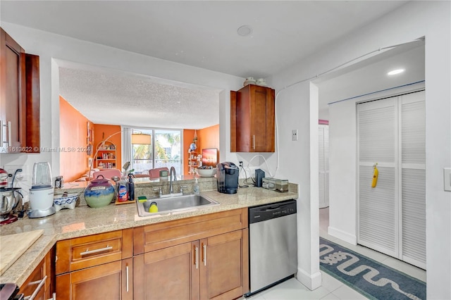 kitchen with light stone counters, a textured ceiling, sink, dishwasher, and light tile patterned flooring