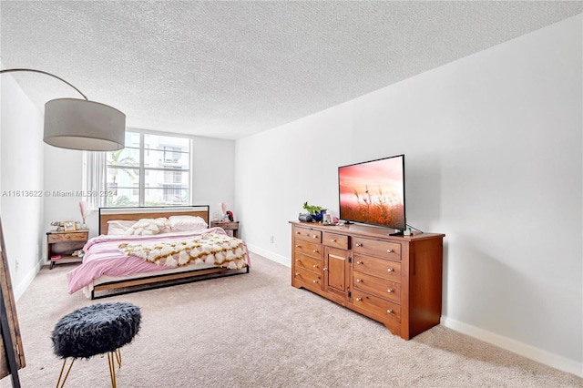 bedroom featuring light colored carpet and a textured ceiling