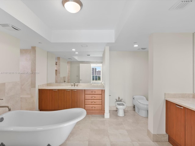 bathroom with a tub, vanity, a bidet, and toilet