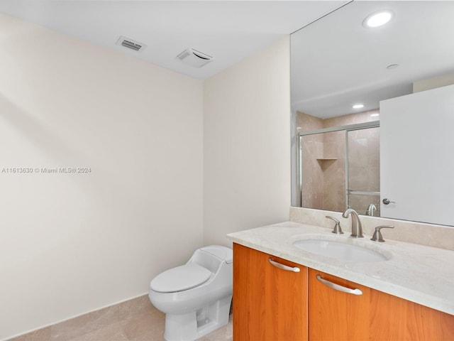 bathroom with tile patterned flooring, vanity, toilet, and a shower with door