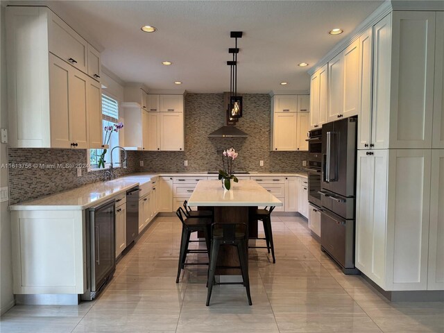 kitchen featuring black appliances, ventilation hood, pendant lighting, sink, and backsplash