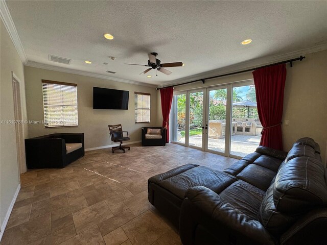 tiled living room with french doors, a textured ceiling, ceiling fan, and ornamental molding