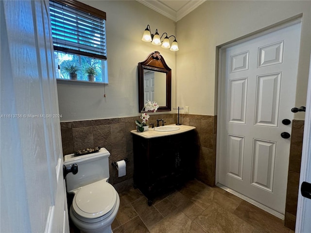 bathroom with vanity, tile walls, crown molding, toilet, and tile patterned flooring